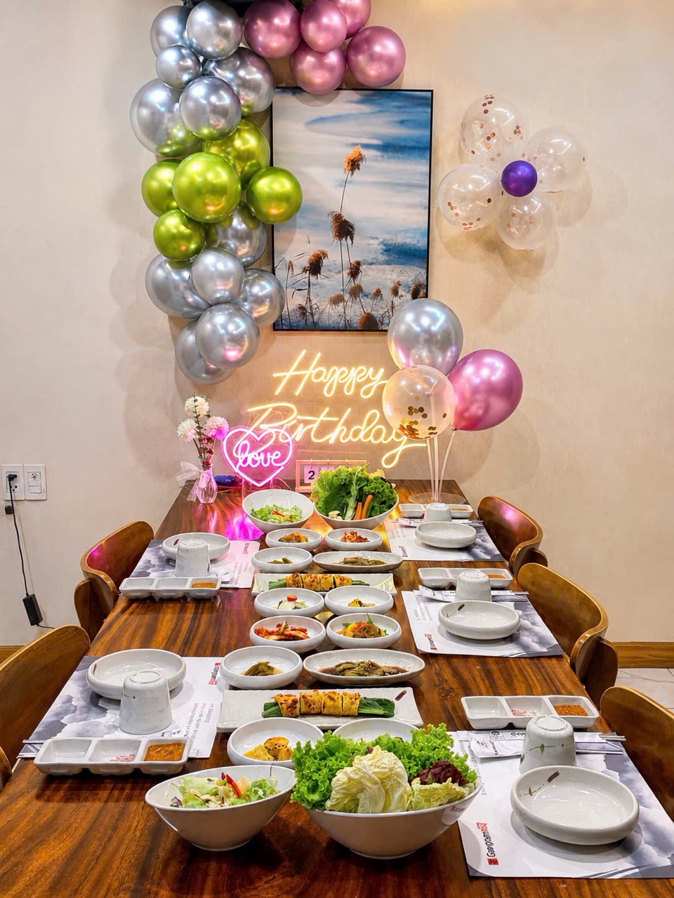 풍선과 네온 사인으로 장식된 강남비비큐 생일 테이블